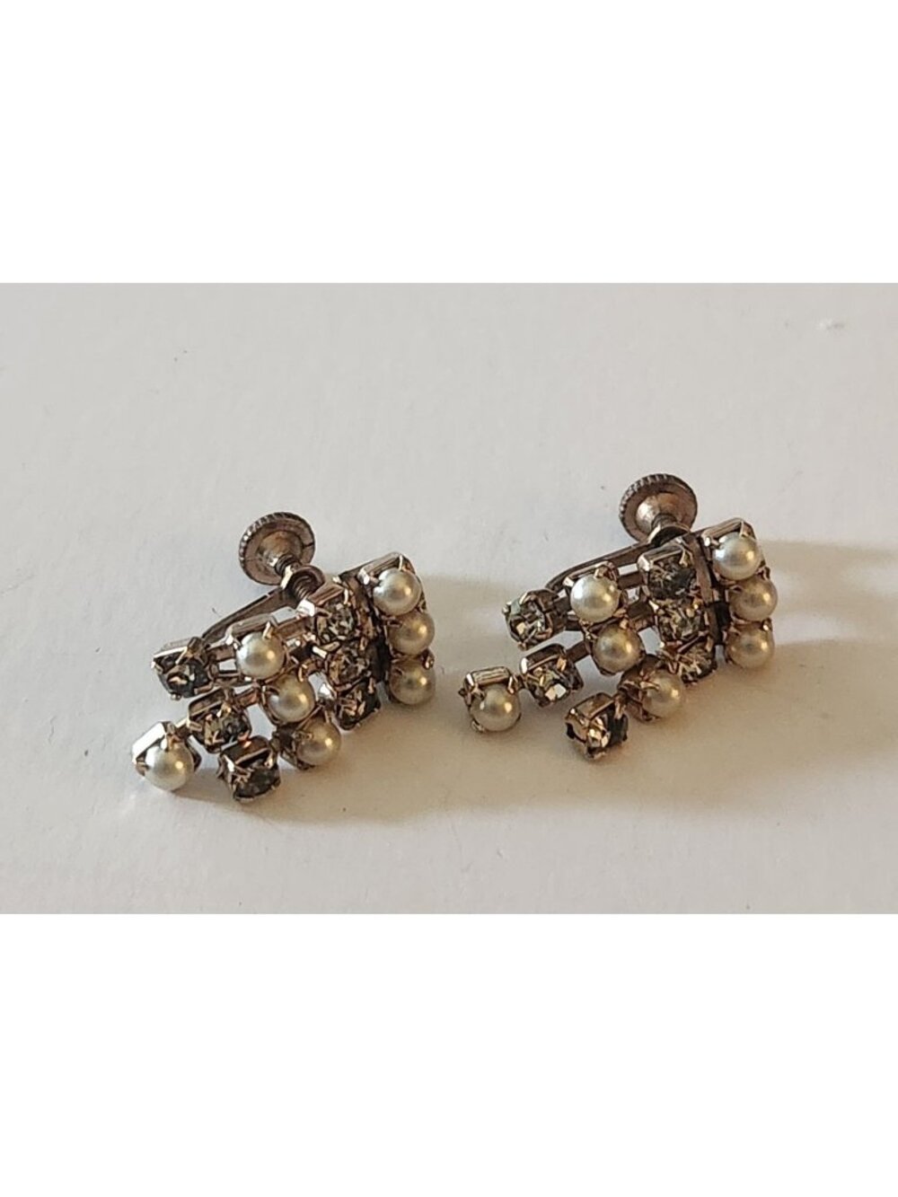 silvertone screw-back earrings featuring prong-set rhinestones and small faux pe